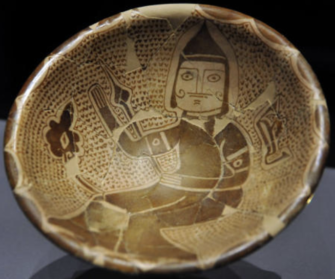 A tenth century lustreware bowl from Iraq, painted with a mounted rider whose face is drawn in full, holding a weapon